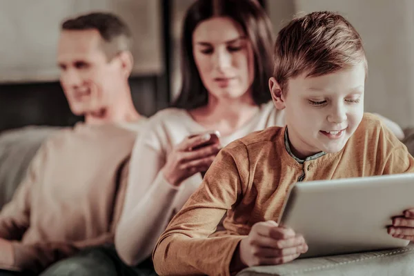 Сконцентрированный ребенок смотрит на экран своего планшета — стоковое фото