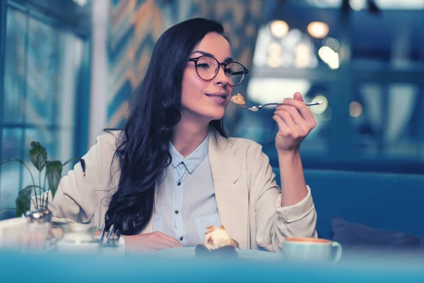 Femme aux cheveux longs détendue dégustant un dessert savoureux à la cafétéria — Photo