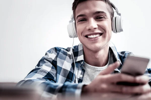 Positieve student genieten van de muziek terwijl het dragen van de nieuwe hoofdtelefoons — Stockfoto