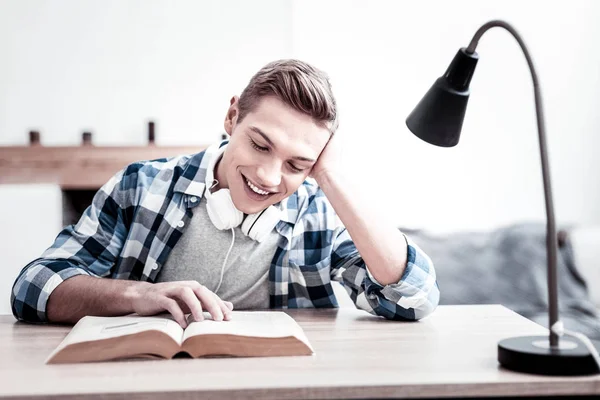 Емоційне студентське почуття вражене і посміхається під час читання — стокове фото
