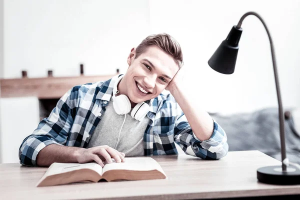 Emotionaler Student lächelt und genießt sein interessantes Buch — Stockfoto