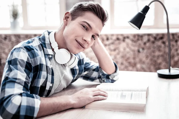 Attractive person smiling while sitting with a book — Stock Photo, Image