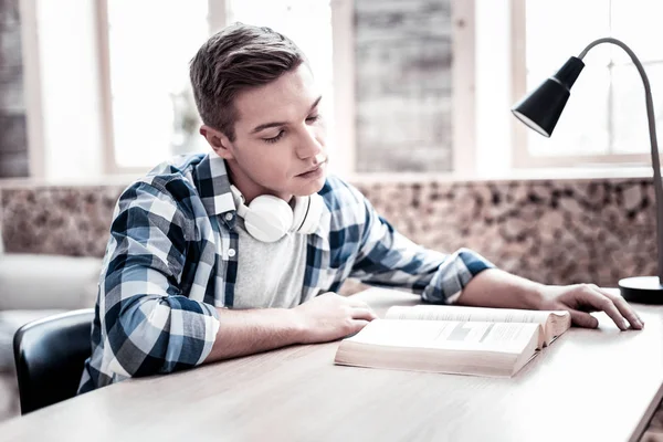 Tired young person leaning his head while reading alone — Stock Photo, Image