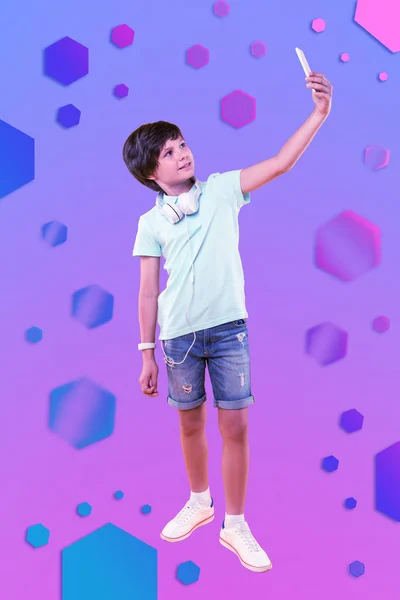 Fröhlicher fröhlicher Junge macht Selfie im Hintergrund — Stockfoto