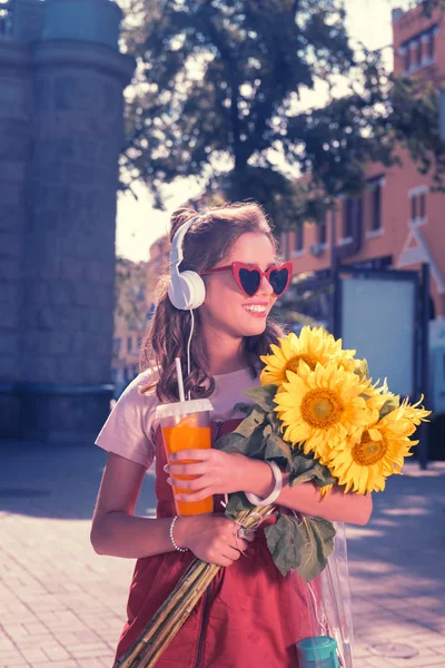 Chica radiante feliz se siente sorprendida después de recibir girasoles en su cumpleaños — Foto de Stock