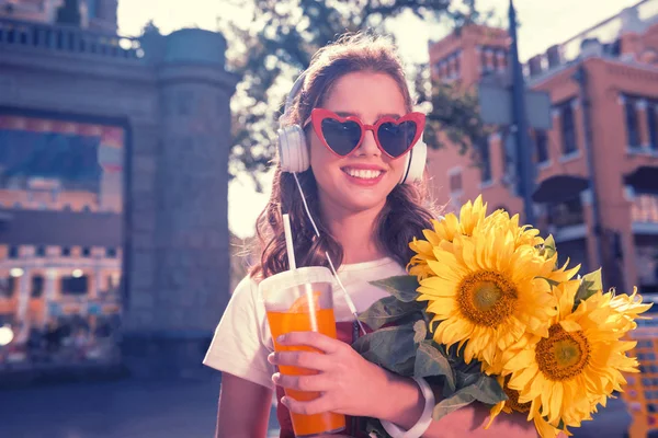 Cuidando de cabelos escuros filha indo para seus pais com belos girassóis — Fotografia de Stock