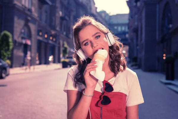 Menina bonita com olhos azuis apreciando o sabor de delicioso sorvete — Fotografia de Stock