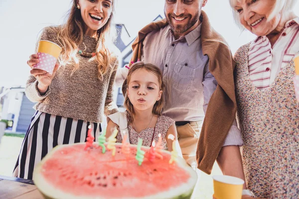 Allvarlig födelsedagsbarnet blåsa ljusen på vattenmelon — Stockfoto