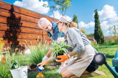 Sarışın karısı çiçek dikim sırasında kocasıyla iletişim