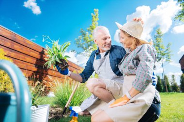 Gülen adam birlikte çiçek dikim iken onun çekici karısı sarılma Bakımı