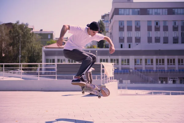 Jovem sério pulando alto com skate — Fotografia de Stock