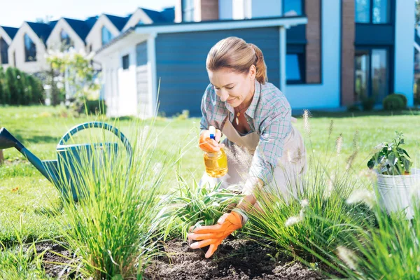 Cura bel giardiniere spruzzando un po 'd'acqua sulle sue piante preferite — Foto Stock