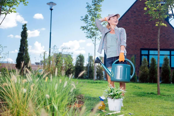 Lachende vrouw dragen van denim shorts houden grote tuin sprinkler — Stockfoto