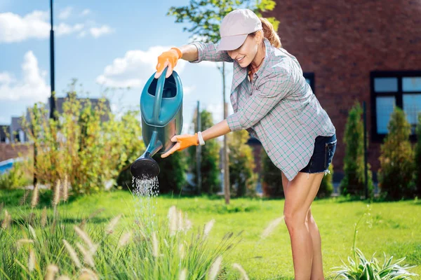 Mulher de família bem sucedida plantando seu canteiro de flores fora da casa — Fotografia de Stock