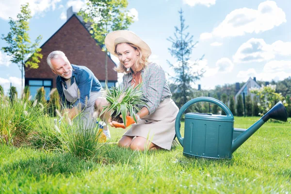 Blonde-haired vrouw gelukkig gevoel terwijl het verzorgen van de omgeving met haar man — Stockfoto