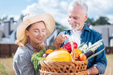 Blonde-haired family woman enjoying the view of their own harvest clipart