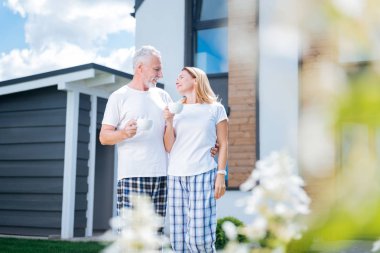 Sevecen adam mutlu eşi onların avluda kahve içme sarılma sakallı