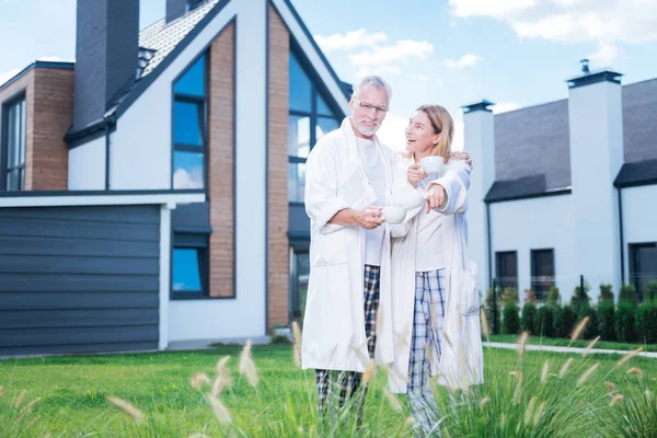 Sarışın sevgi dolu karısı kocası onların yeni bitki avluda gösterilen.