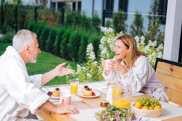 Casal de esposa madura e marido desfrutando de sua manhã tomando café da manhã saboroso — Fotografia de Stock