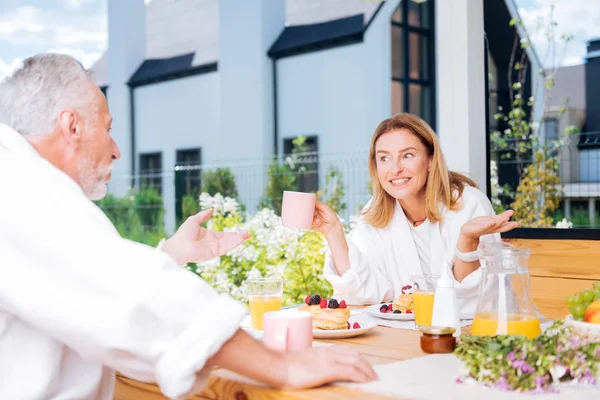 Bela esposa radiante sentindo-se animado ao planejar viagem em família durante o café da manhã — Fotografia de Stock