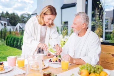 Sevgi dolu yakışıklı karısı kocası için sabah krep meyve ile kesme