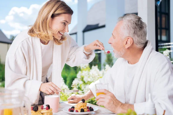Strahlende Hausfrau, die sich beim Frühstück um ihren Mann kümmert — Stockfoto