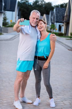 Gülümseyen adam ince karısını çalıştırdıktan sonra fotoğraf yaparken sarılma sakallı