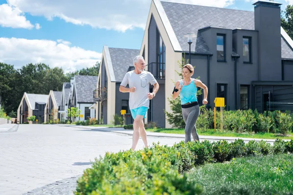 Gesundes Paar von Geschäftsleuten läuft morgens gemeinsam in der Nähe ihres Hauses — Stockfoto