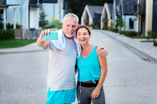 Moderna pareja de hombres de negocios maduros haciendo selfie después de correr juntos —  Fotos de Stock