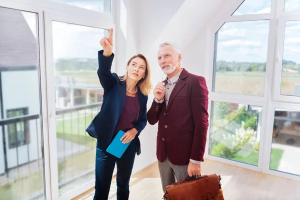 Reicher Geschäftsmann denkt über Kauf eines neuen Hauses in der Nähe von Makler nach — Stockfoto