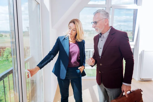 Erfahrene Immobilienmaklerin zeigt Fensterblick auf ihre reiche Kundin — Stockfoto