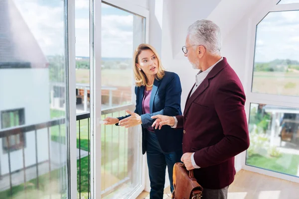Blonda-păr agent imobiliar arată balcon frumos de casă modernă clientul ei — Fotografie, imagine de stoc