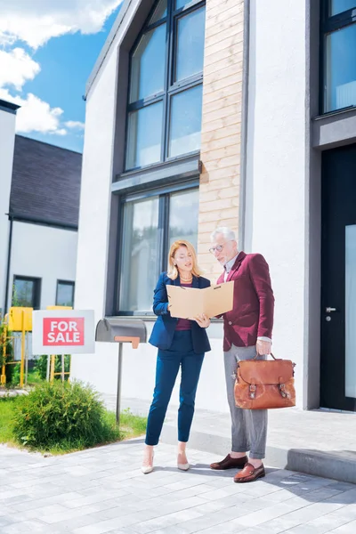 Zakenman dragen stijlvolle elegante pak het controleren van documenten tijdens het kopen van huis — Stockfoto