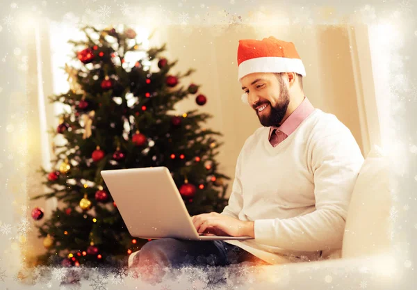 Улыбающийся бородатый мужчина в новогодней шляпе во время видеочата с другом — стоковое фото