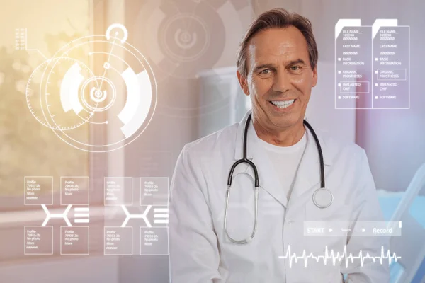 Alegre doctor teniendo un estetoscopio en su cuello y sintiéndose feliz — Foto de Stock