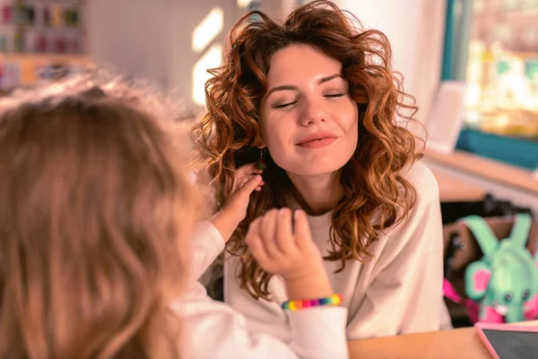 Cheerful pretty mommy keeping eyes closed from pleasure — Stock Photo, Image