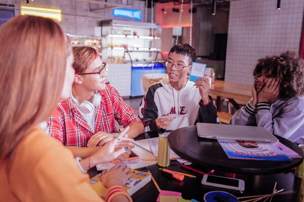Позитивный восторженный азиатский мальчик демонстрирует свой выбор
