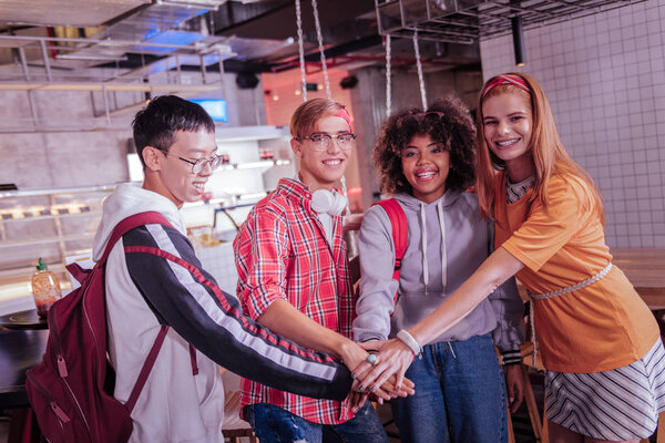 Удивительная длинноволосая девушка, стоящая рядом со своими друзьями
