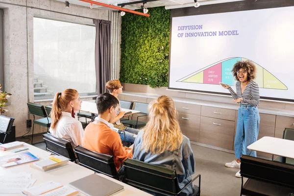 Happy international girl pointing at board for presentation