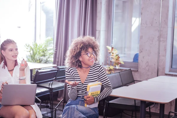 Positiva mujer internacional encantada sosteniendo sus libros — Foto de Stock