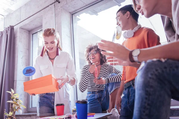 Positiv glad kvinnliga person sätta lådan på bordet — Stockfoto