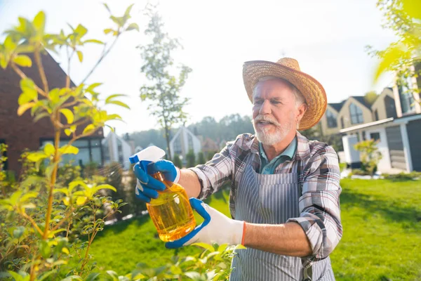 Aantrekkelijke aangename gepensioneerde man het verzorgen van de tuin — Stockfoto