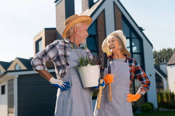 Улыбающаяся счастливая пара, стоящая рядом с домом — стоковое фото