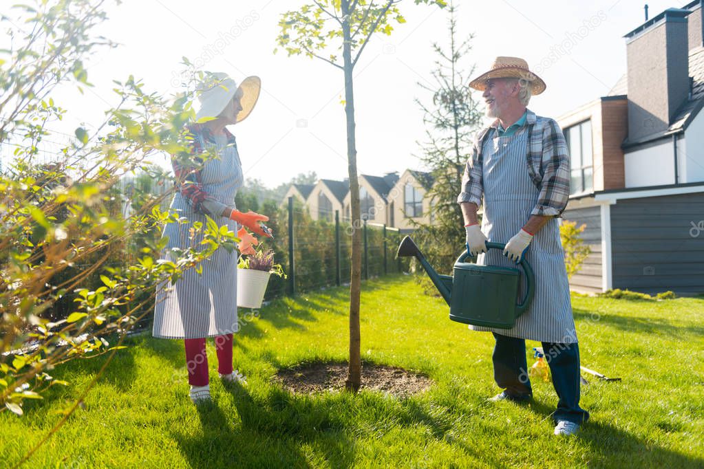 Pleasant involved couple spending time together in the garden