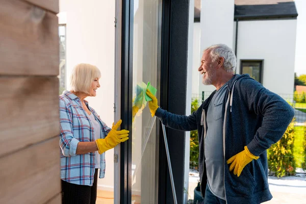 Pozitivní postarší muž a žena čištění dveří letního domu — Stock fotografie
