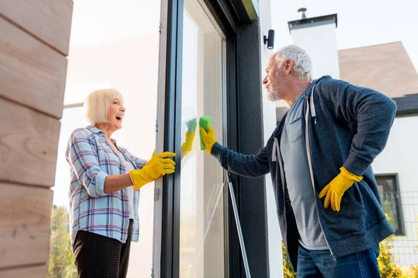 Krásná starší dáma pocit pozitivní při čištění dveří se svým manželem — Stock fotografie