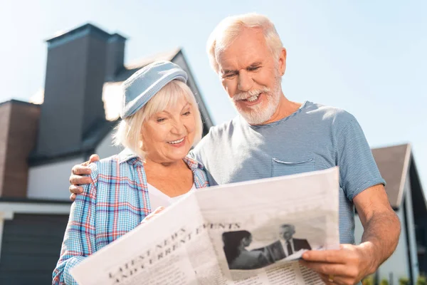 Jubilados feliz pareja leyendo su periódico de la mañana juntos fuera de casa — Foto de Stock