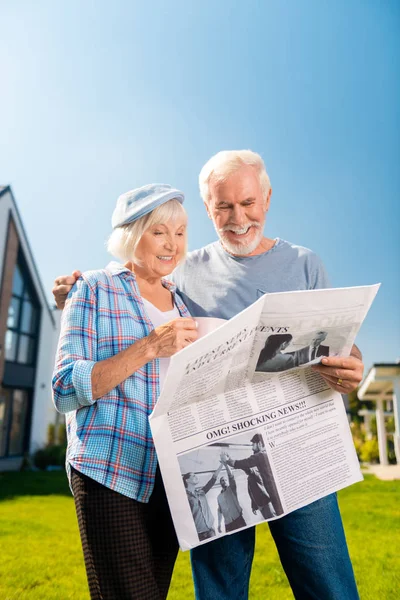 Muž a žena opouští svůj soukromý dům při čtení novin — Stock fotografie