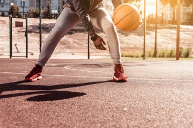 Dinamik oyun. Bir oyun oynarken bir basketbol topu tutan güzel genç adam