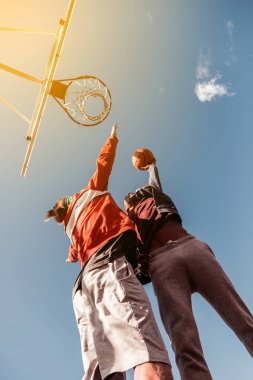 Low angle of young well built men throwing the ball clipart